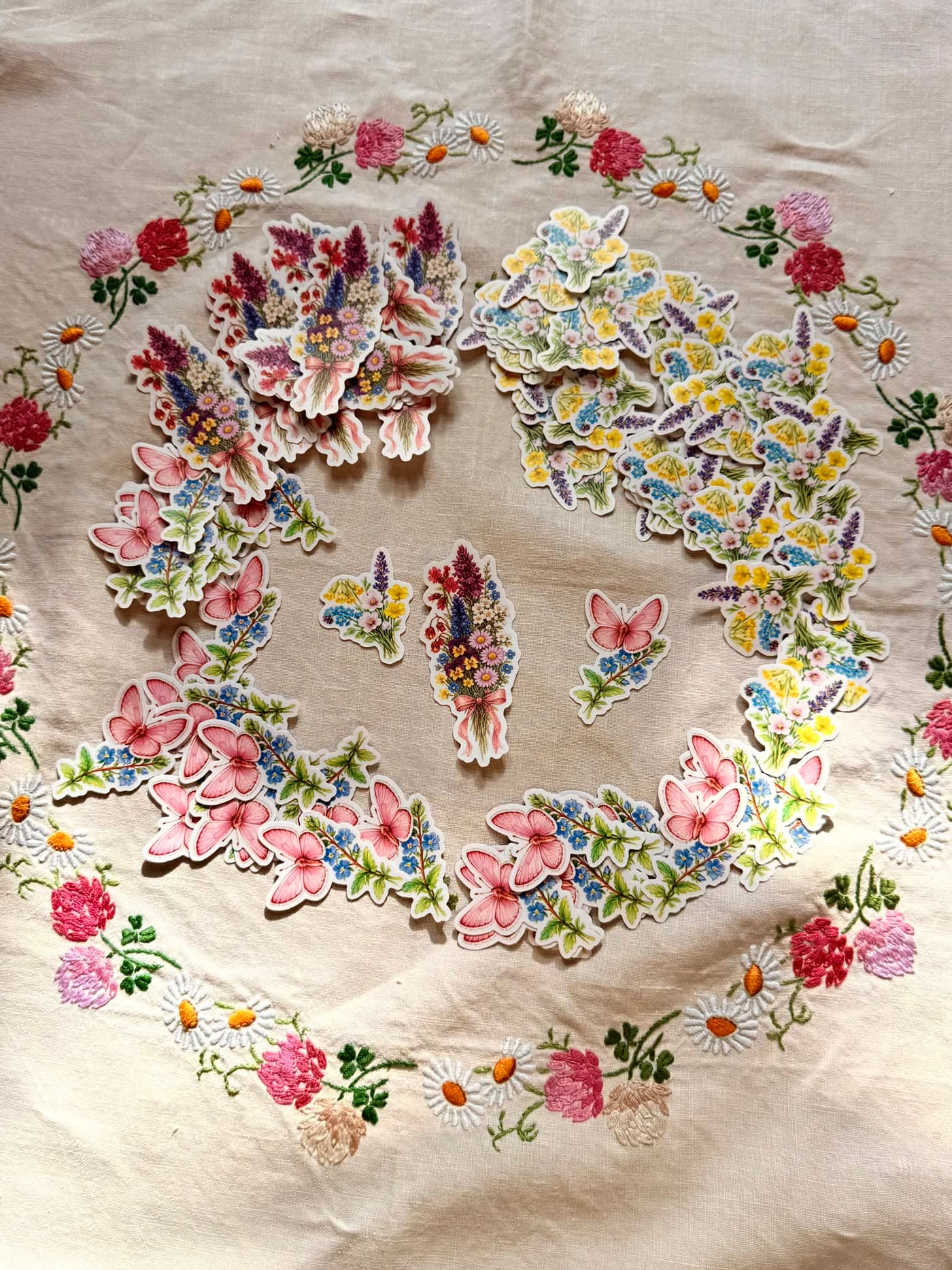 A small set of individual die-cut botanical stickers, drawn to match the month's flower, on a matte sheet.